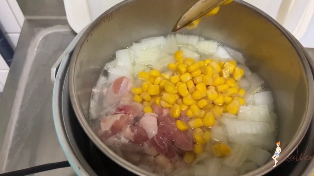 5.然後把雞腿肉、玉米，以及拌散的火腿玉米濃湯粉包加進去，蓋上鍋蓋煮約5分鐘。